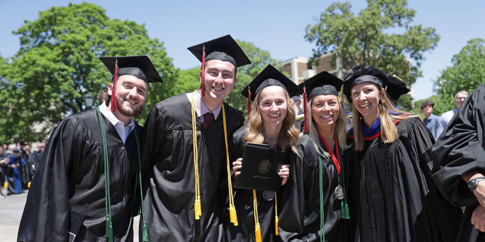 Graduates pose for a photo after Commencement